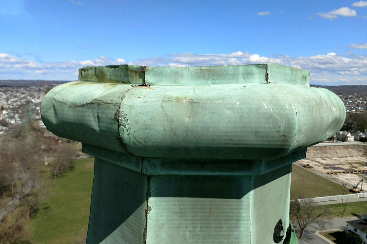 The base of the spire was also damaged. This photo shows the damaged base before repair